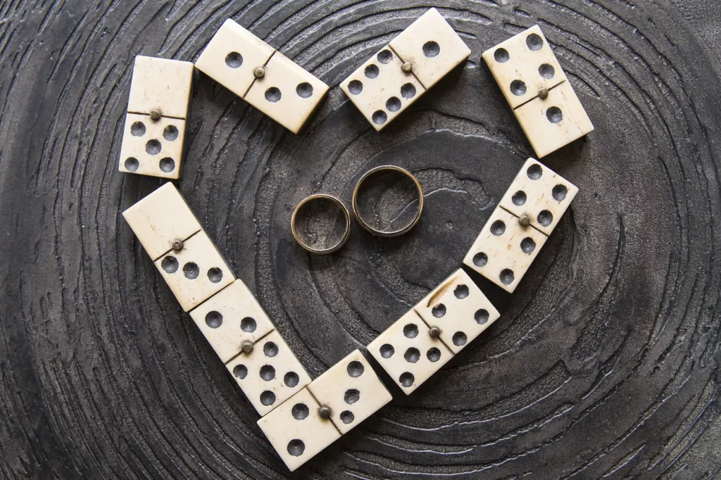 Unieke trouwfoto met ringen en dominostenen in hartvorm