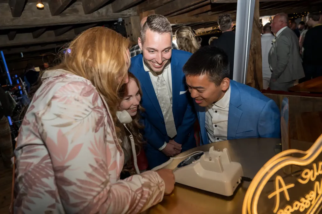 Bruiloftsgasten lachen en spreken een bericht in op het audio-videogastenboek van Daniel Vos Fotografie