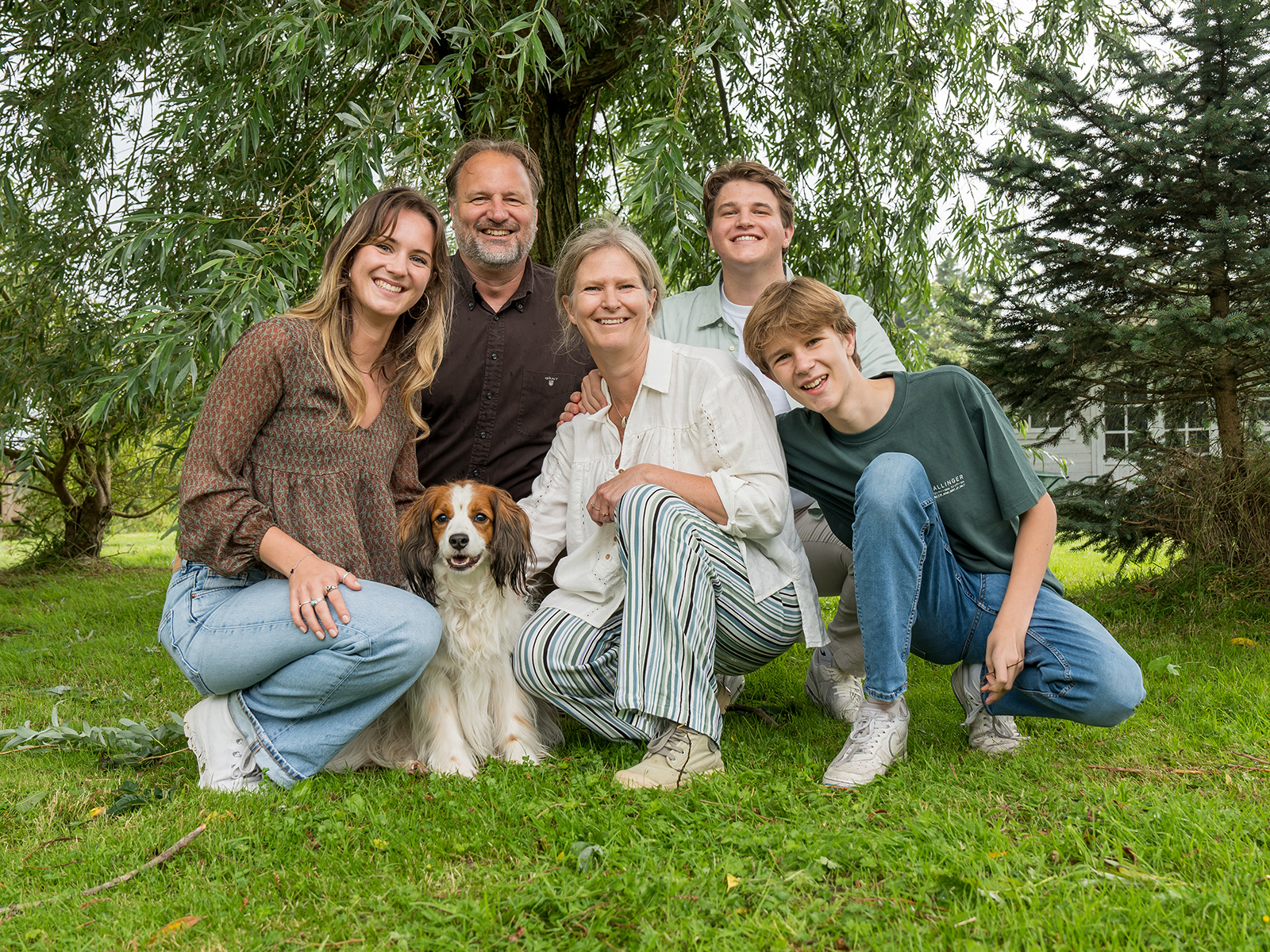 Ontspannen gezinsportret inclusief hond in een eigen tuin in Broek op Langedijk, gefotografeerd door Daniël Vos Fotografie