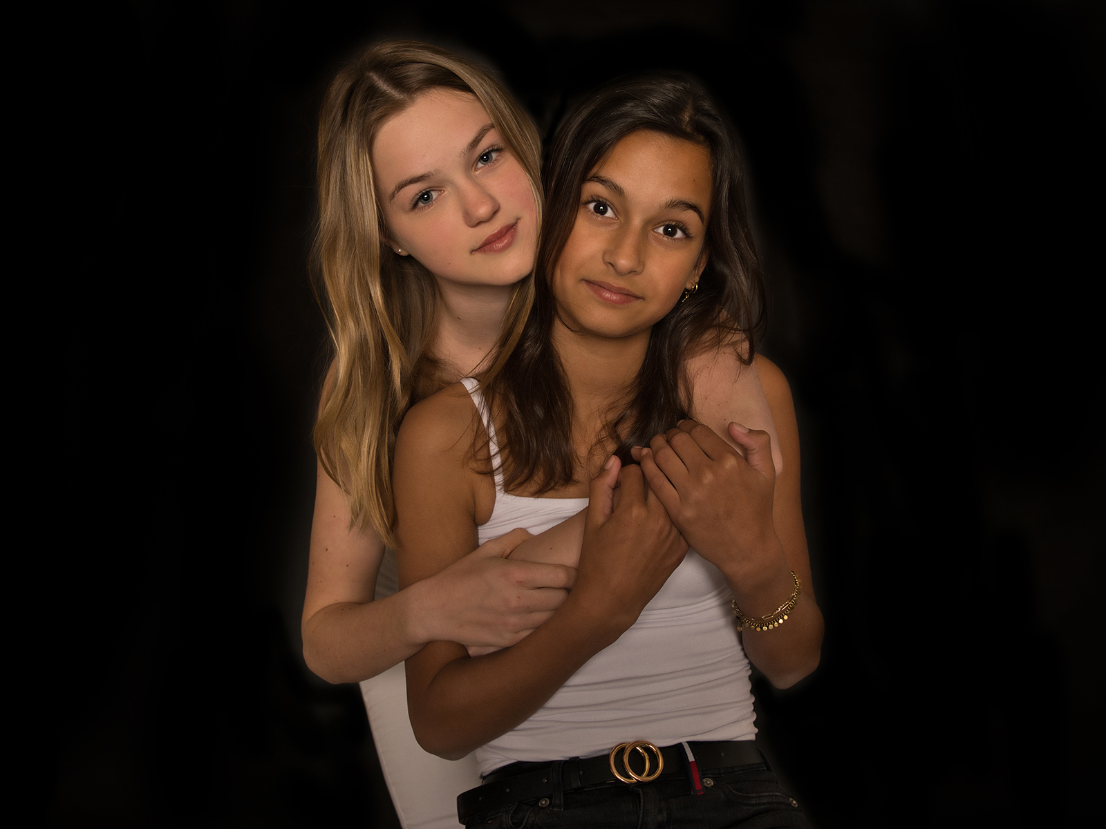 Artistiek duo-portret van twee meiden tegen een zwarte achtergrond, gefotografeerd door Daniël Vos Fotografie in Broek op Langedijk